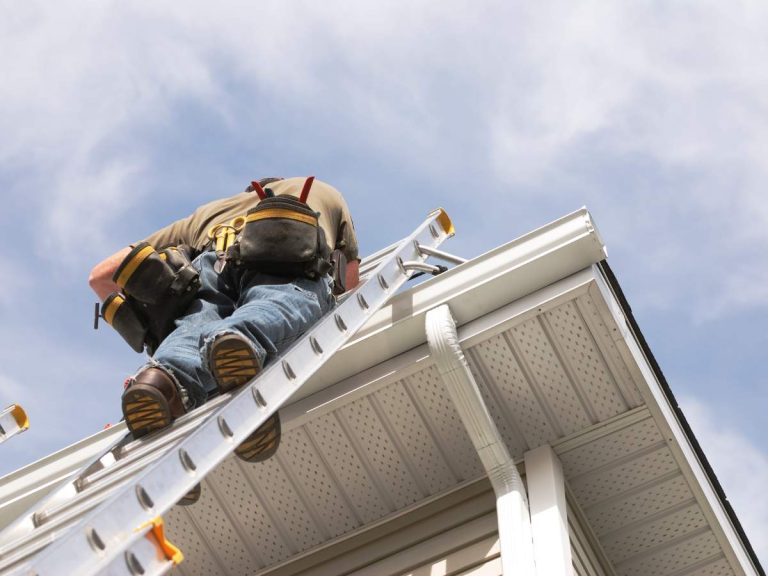 A handyman performing seasonal maintenance tasks on a home's exterior