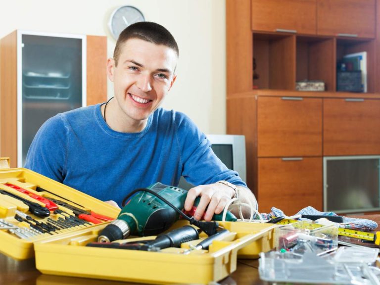 A homeowner organizing tools and space in preparation for a handyman visit.