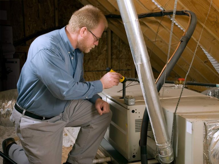 Handyman inspecting attic insulation, one of the most overlooked areas in home maintenance