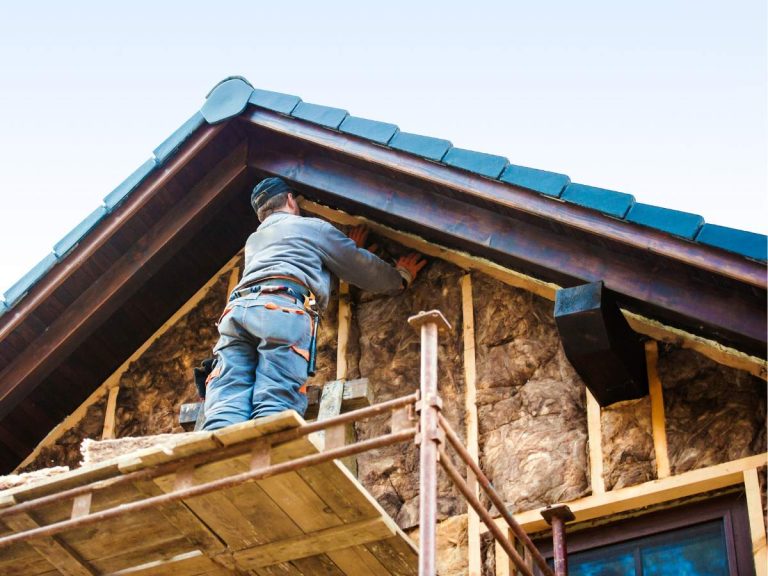 A handyman installing eco-friendly insulation in a home