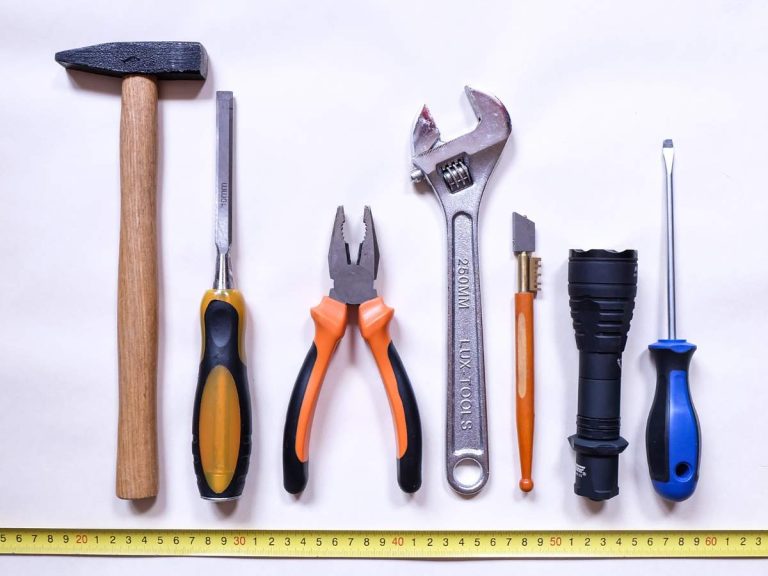 A homeowner debating between DIY installation and hiring a handyman for home improvement, with tools and repair items on the table.