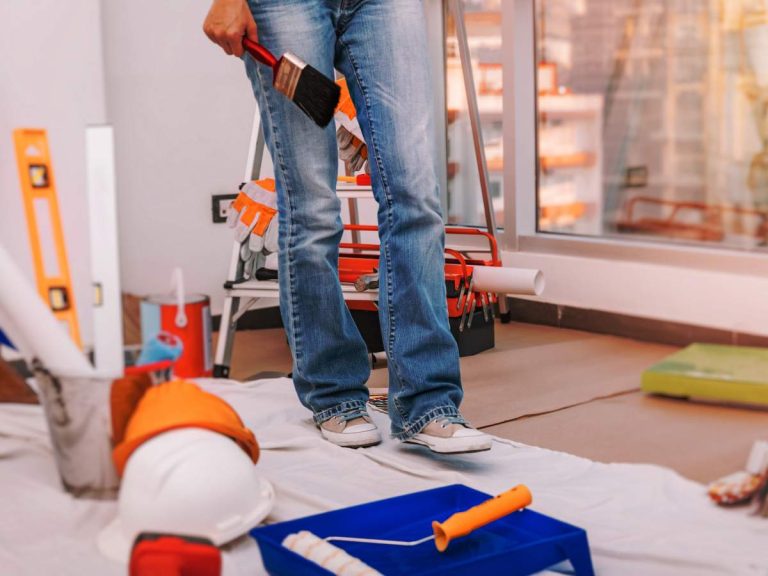 A homeowner following best practices for safe home installations, using proper tools and safety equipment during a DIY project.
