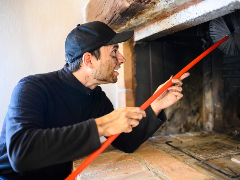 A professional inspecting and cleaning a chimney as part of regular maintenance.